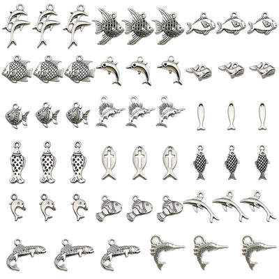 Metallic dolphin and fish charms arranged on a light background