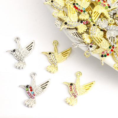 Assorted hummingbird charms arranged on a white surface