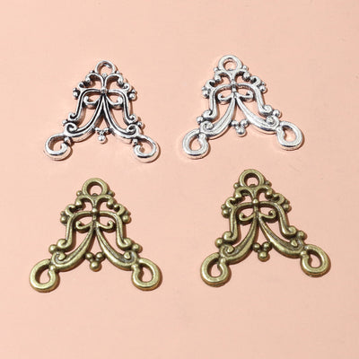 Ornate Double Loop Metal Connector Charms in Two Antique Finishes assortment on a plain background