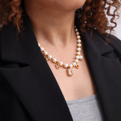 Gold seashell pearl necklace with zircon tags worn on model