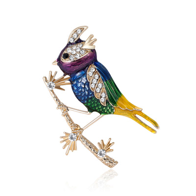 Front view of the colorful enamel bird on pine branch brooch decorative clothing pin on a white background