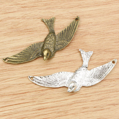 large flying bird charms arranged together on a white background