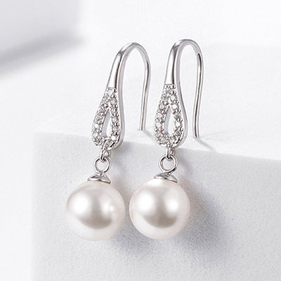 White gold teardrop CZ hook pearl drop earrings on white block