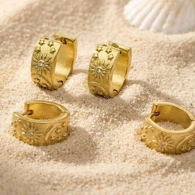 Gold sun moon star embossed huggie hoops on sand