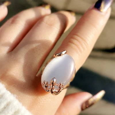 Front view of large oval opalescent cabochon in a rose-gold-tone setting