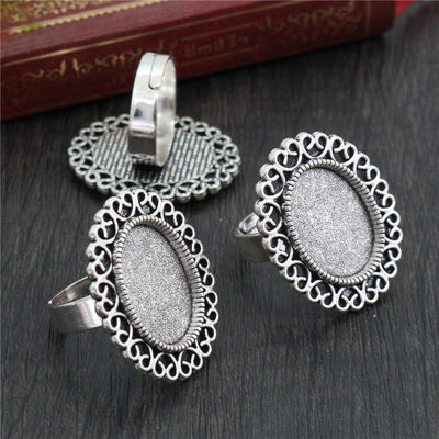 Ornate Oval Cabochon Ring Bezel Setting in Antique Silver assortment on a plain background