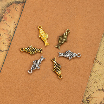 Main product image of the textured fish charm showing a small double-sided fish with crosshatched scale texture