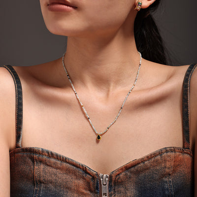 Model wearing natural stone bead necklace with black teardrop pendant