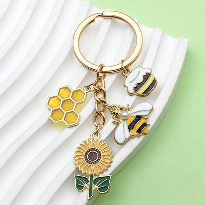 Image 1 showing a keychain with some flowers and bees.
