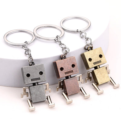 Three metal robot keychains in silver, copper, and bronze colors.