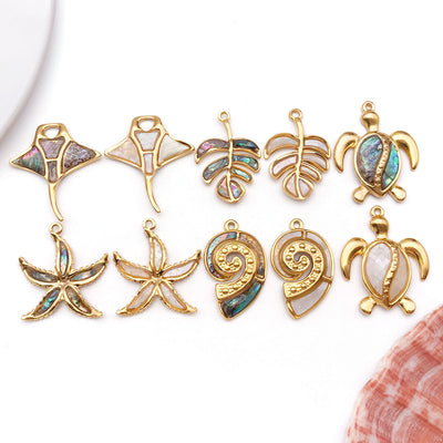 Gold-tone turtle and seashell charms arranged on a light background
