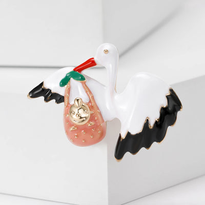Product display showing a white crane carrying a pink handbag with black-tipped wings