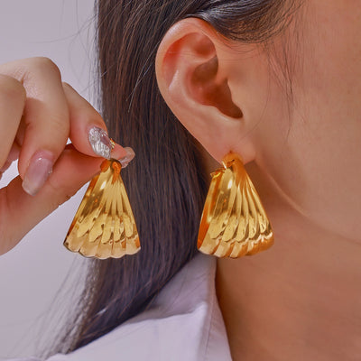 Model wearing gold twisted multi-layer half hoop earrings close-up