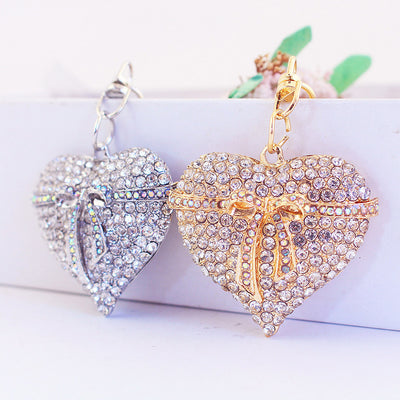 Gold-tone and silver-tone rhinestone heart bow keychains displayed together.