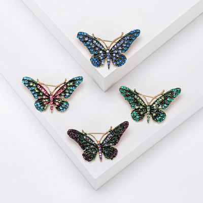 Compact butterfly with dark crystal outlines and multicolor wing stones brooch front view