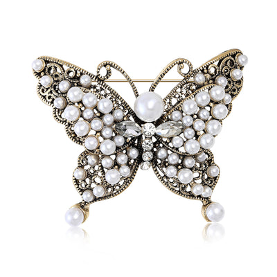 Antique gold pearl filigree butterfly brooch front on white