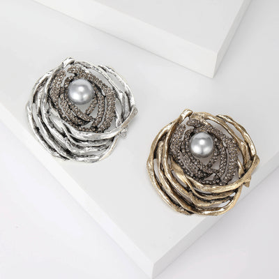 Product display showing a textured circular twig nest surrounding a white faux pearl