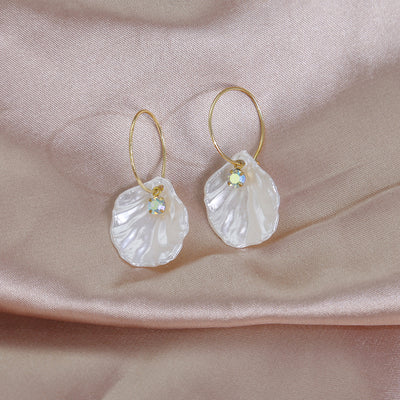 White shell gold hoop drop earrings with crystal accents on pink satin