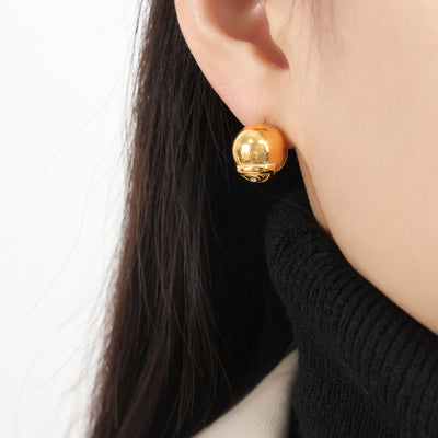 Model wearing gold evil eye ball stud earring on earlobe