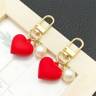 Overview showing the available color and design variations of the red resin heart pearl-look metal clasp dangle keychain