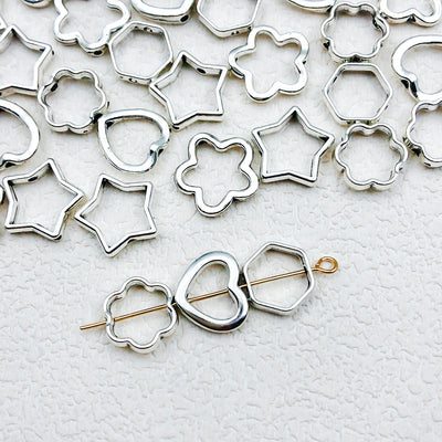 Metallic connector jewelry findings arranged on a light background