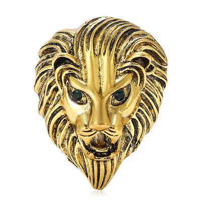 Gold lion head brooch with green gemstone eyes front view