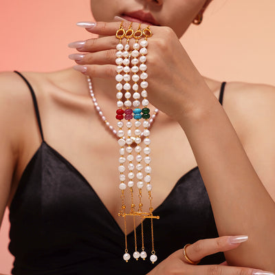 Four pearl bracelets with purple red turquoise green stones held
