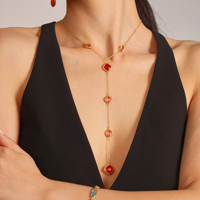 Red Czech glass gold Y-lariat necklace worn on black plunge dress