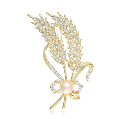 Gold wheat ear brooch with pearl bow on white background
