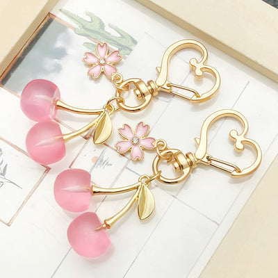 Overview showing the available color and design variations of the pink cherry strawberry and blossom metal clasp keychai