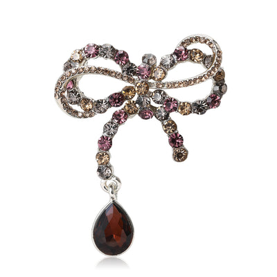 Front view showing the crystal ribbon bow brooch with large faceted teardrop dangle