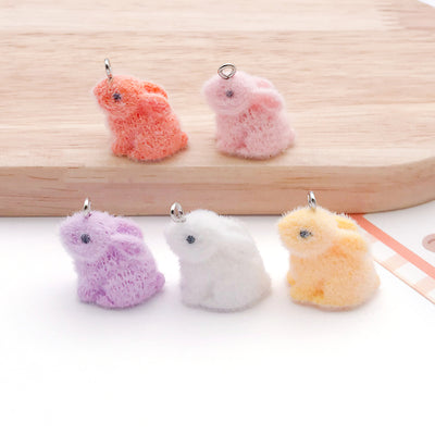 Multicolor rabbit charms arranged on a light background