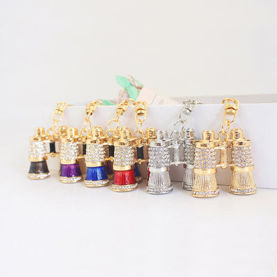 A row of binocular keychains in multiple colors with clear stone detailing.