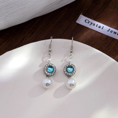 Silver teal crystal halo pearl drop hooks on white plate