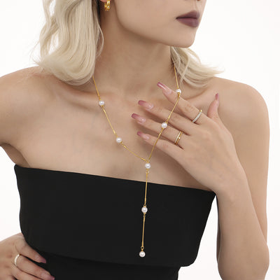 Gold Y-shape pearl station lariat necklace worn on model chest