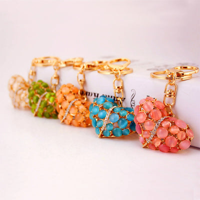 A row of pink, blue, peach, green, and white heart keychains with gold-tone hardware.