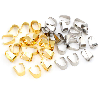 Front overview of small pinch bails for pendants in gold and silver tones arranged on a light background