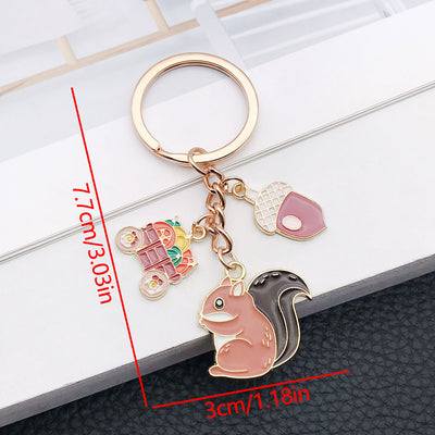 Front product photo of autumn squirrel acorn harvest wagon enamel charm keychain showing the pictured design arrangement