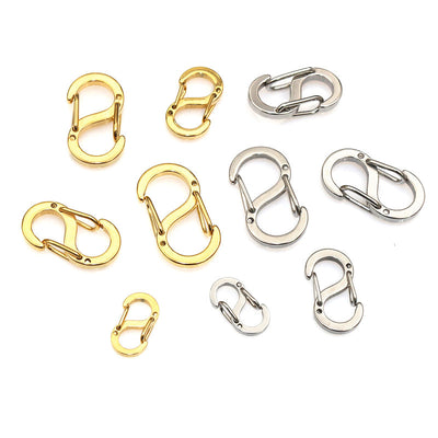 Overview of gold and silver tone mini s shaped spring clasp components arranged on white