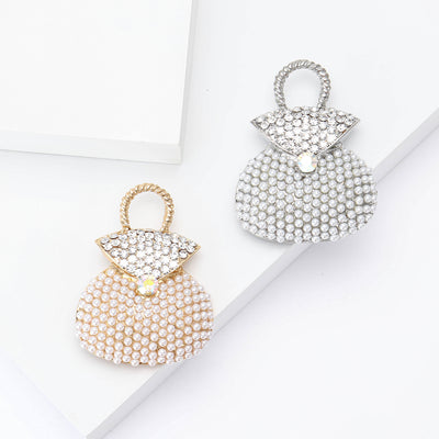 Front view of the crystal handbag brooch with bow and blue accent decorative clothing pin on a white background