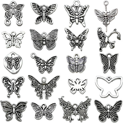 Antique silver butterfly charms arranged on a light background