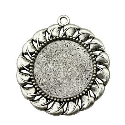 Leaf Border Round Cabochon Settings in Two Finishes held in hand for scale