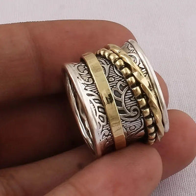 Product view showing antiqued silver and gold-tone engraved spinner wide ring