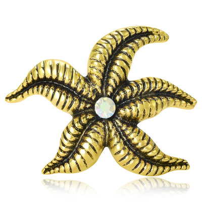 Gold textured starfish brooch with center AB crystal on white