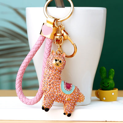 A front product view shows the alpaca keychain with its visible ornament and hanging hardware.