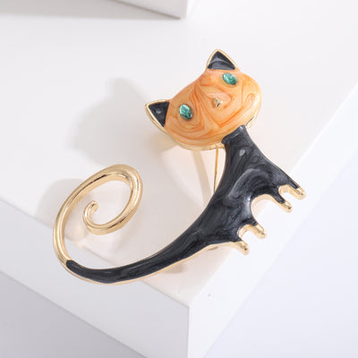 Front view of long tail cat enamel brooch with curled accent decorative metal pin