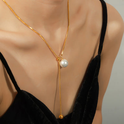 Gold snake lariat pearl necklace worn on mannequin