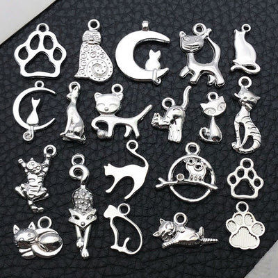 Black cat and cat paw charms arranged on a light background