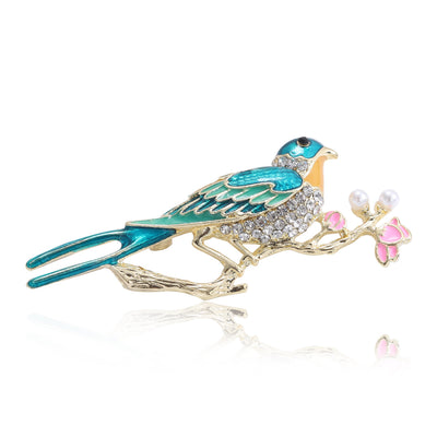 Blue Bird and Pink Blossom Brooch shown against a white display background