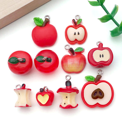 Multicolor apple charms arranged on a light background